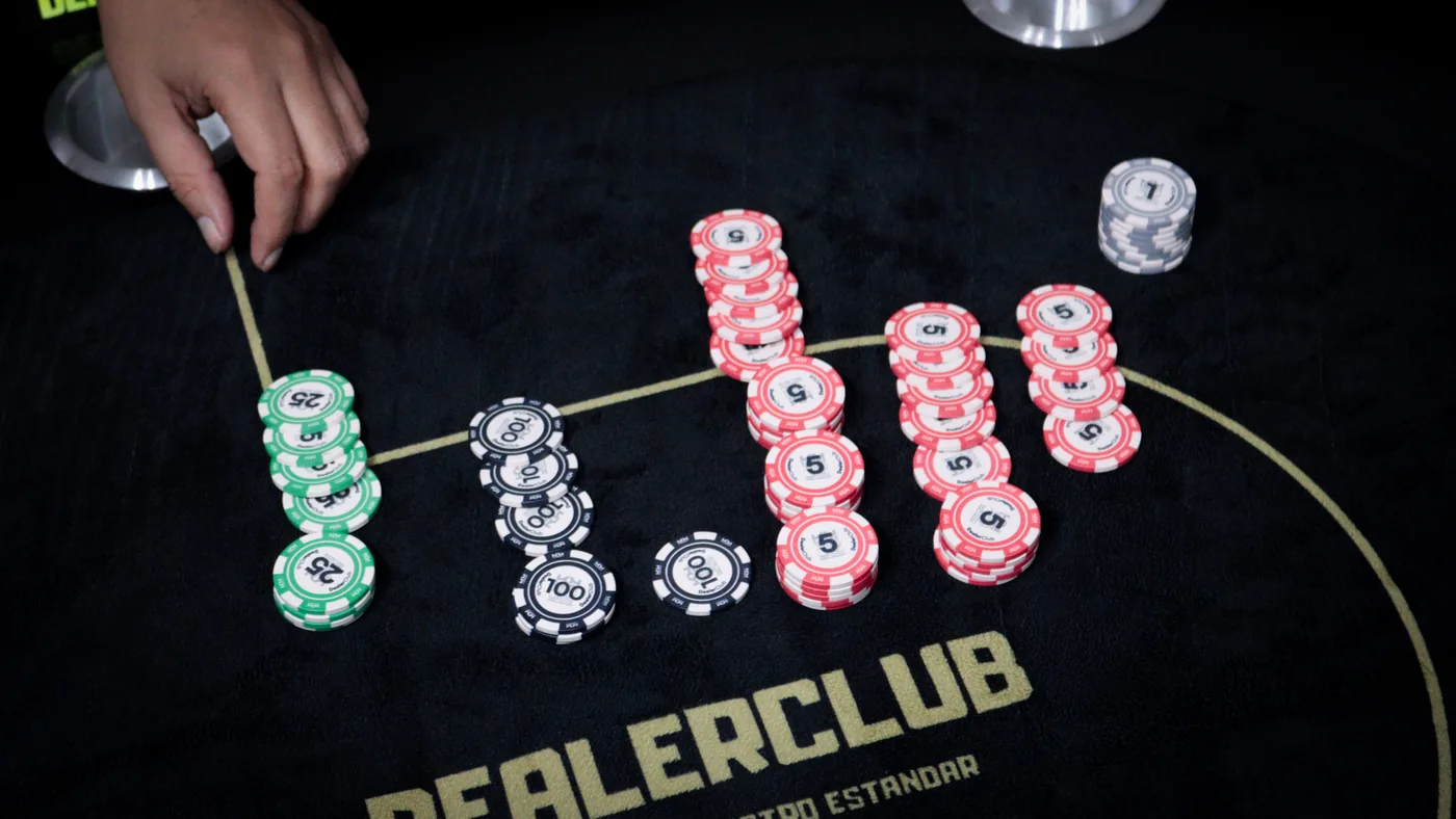 Fichas de DealerClub apiladas sobre el paño de juego