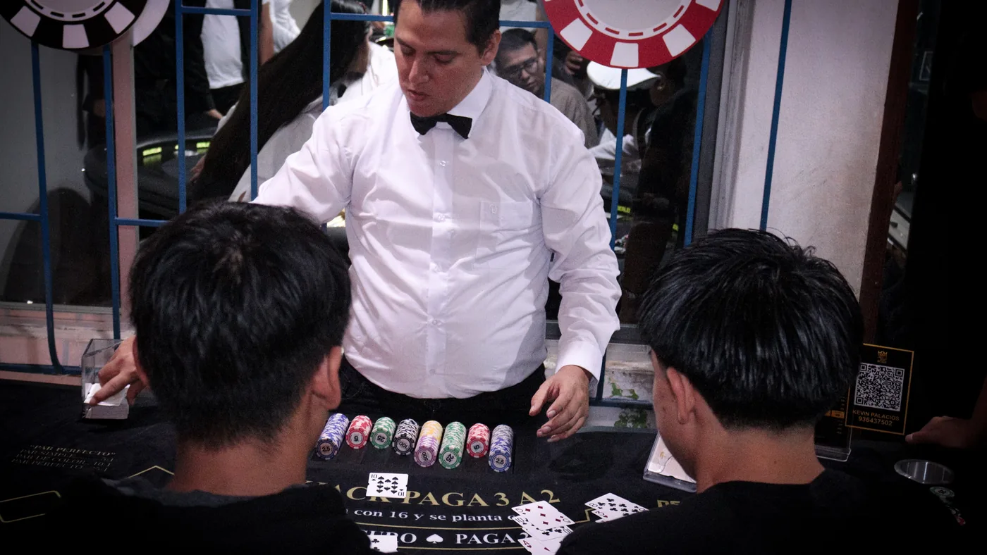 Dealer de DealerClub atendiendo a dos jugadores en mesa de Blackjack